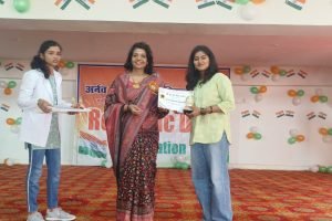 A woman holds a certificate while surrounded by a group of smiling people celebrating her achievement.